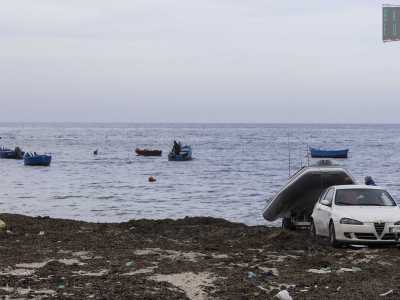...mentre un signore sta tirando su dall�acqua con il carrello un gommone grigio